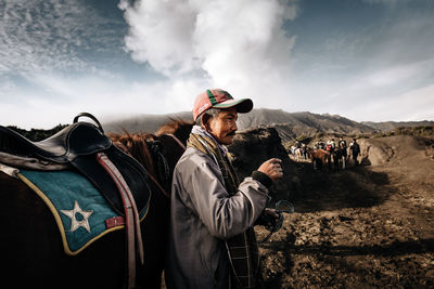 Men standing on mountain against sky