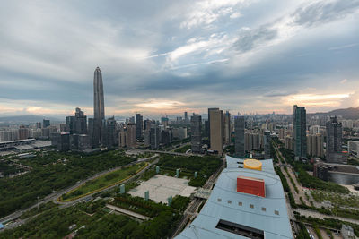 Aerial view of city buildings against cloudy sky