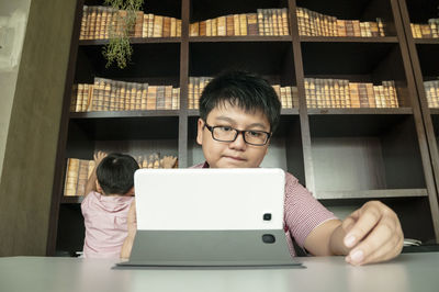 Portrait of cute boy sitting on table