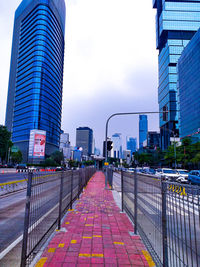 Street amidst buildings against sky in city