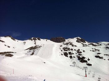 Scenic view of snowcapped mountains against clear blue sky