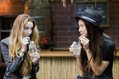 Happy young friends enjoying drinks at a bar