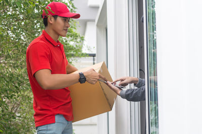 Young man delivering package to customer at doorway