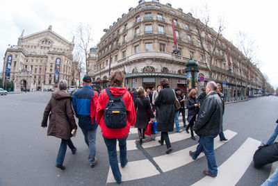 People walking on road along buildings