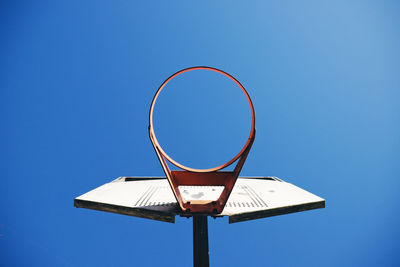 Low angle view of basketball hoop against clear blue sky