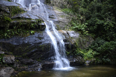 Waterfall from rocks in rainforest