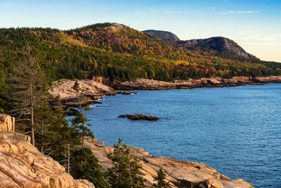 Scenic view of sea and mountains against sky