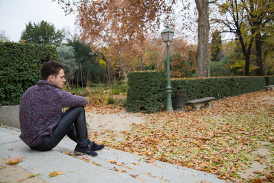 Man sitting in park during autumn