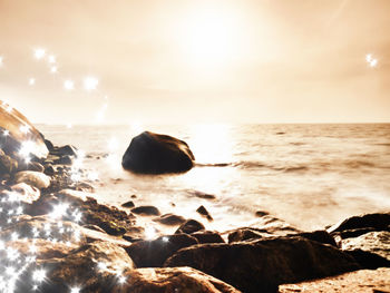 Rocks on beach against sky