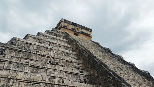 Low angle view of old building against cloudy sky