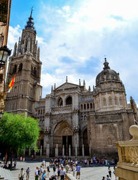 Group of people in front of historic building against sky