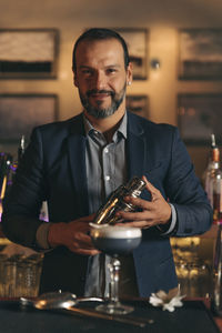 Male bartender preparing cocktail at bar counter