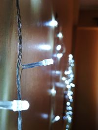 Close-up of illuminated lamp against wall