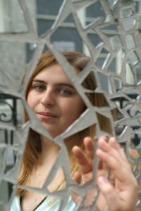 Portrait of beautiful young woman reflecting on mirror