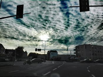 Cars on road in city against sky