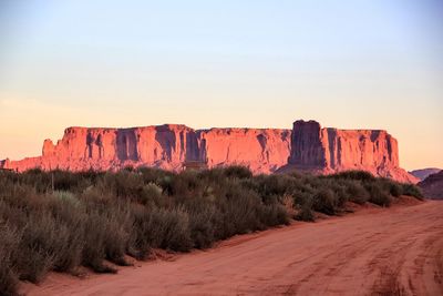 Rock formations at monument valley against sky during sunset