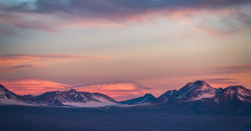 Scenic view of snowcapped mountains against sky during sunset