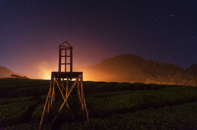 Lifeguard hut on field against sky at night