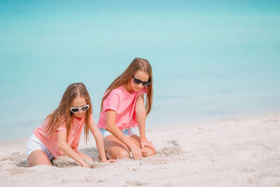 Woman wearing sunglasses on beach against sky