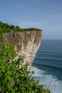 Rock formations by sea against sky