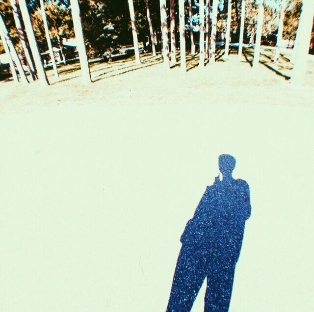 SHADOW OF PEOPLE ON SNOW COVERED FIELD