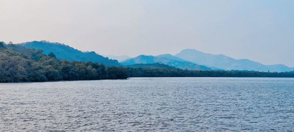 Scenic view of sea and mountains against sky