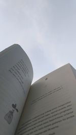 Close-up of text on book against sky