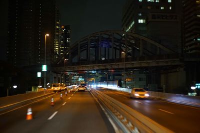 Cars on illuminated street at night