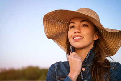 Young woman in a hat against the blue sea.