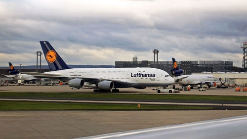 Airplane on airport runway against sky