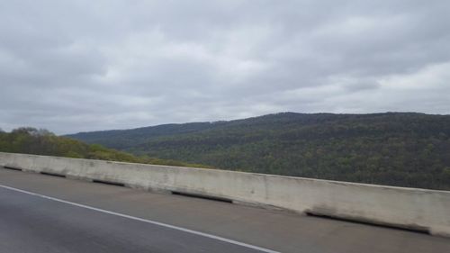 Country road against cloudy sky