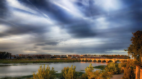 Scenic view of river against cloudy sky