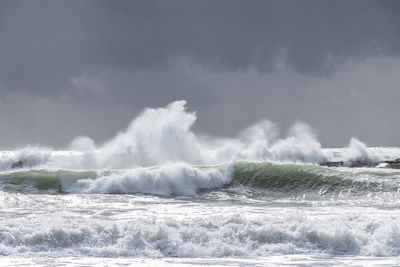 Water splashing in sea against sky