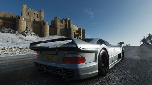 Cars on road by buildings against sky