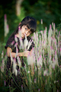 Close-up of woman on purple flowering plants on field