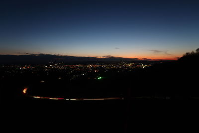 Illuminated city against sky at night