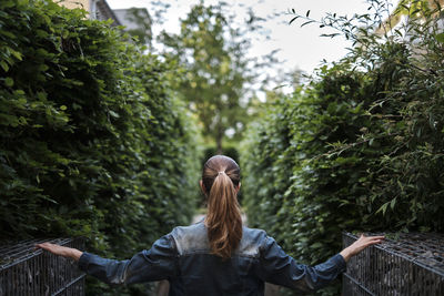 Rear view of young woman walking in forest