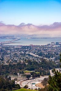 View of cityscape by sea against sky