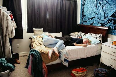 Sisters lying on bed at home