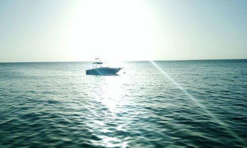 Boat sailing in sea against clear sky