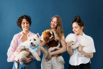 Portrait of woman with dog against black background