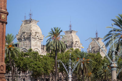 Low angle view of trees and buildings against sky