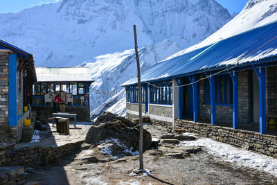 Snow covered house by mountain