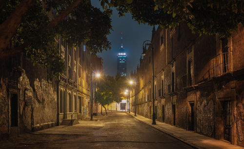 Empty street amidst buildings at night
