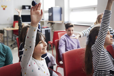 Children raising hands in class