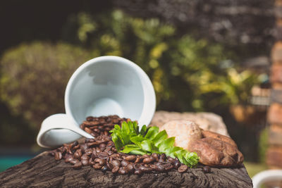 Coffee beans spinning on wood against trees