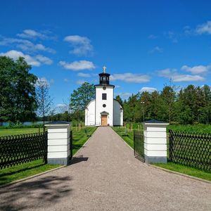 Walkway leading to built structure against blue sky