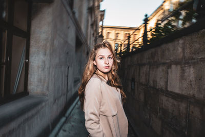 Portrait of woman standing against building