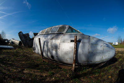 Abandoned airplane on field against sky