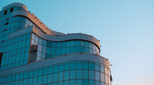 Low angle view of modern building against clear blue sky